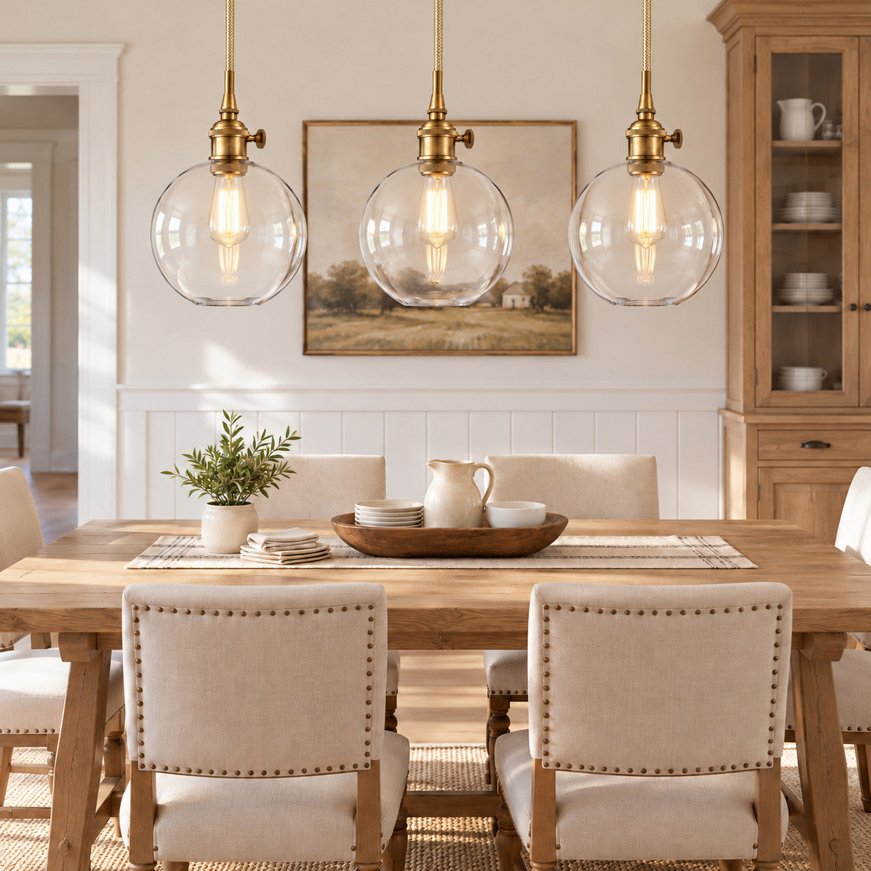 Brass clear-glass globe pendants above a dining table